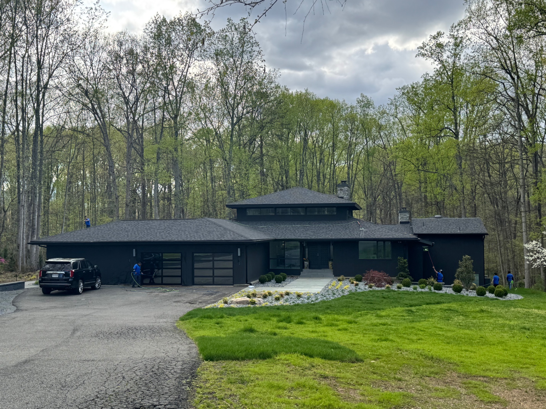 Modern dark-clad home tucked into wooded surroundings